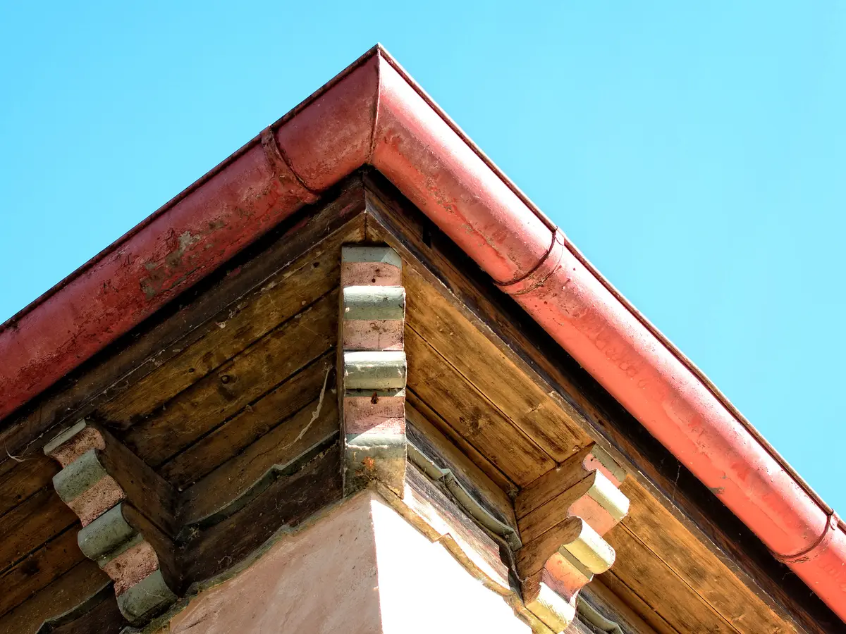Timber soffit and red fascia at the corner of a roof