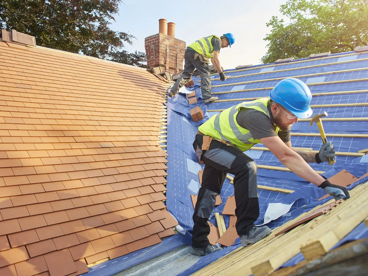 Roofers laying a new roof covering on battens