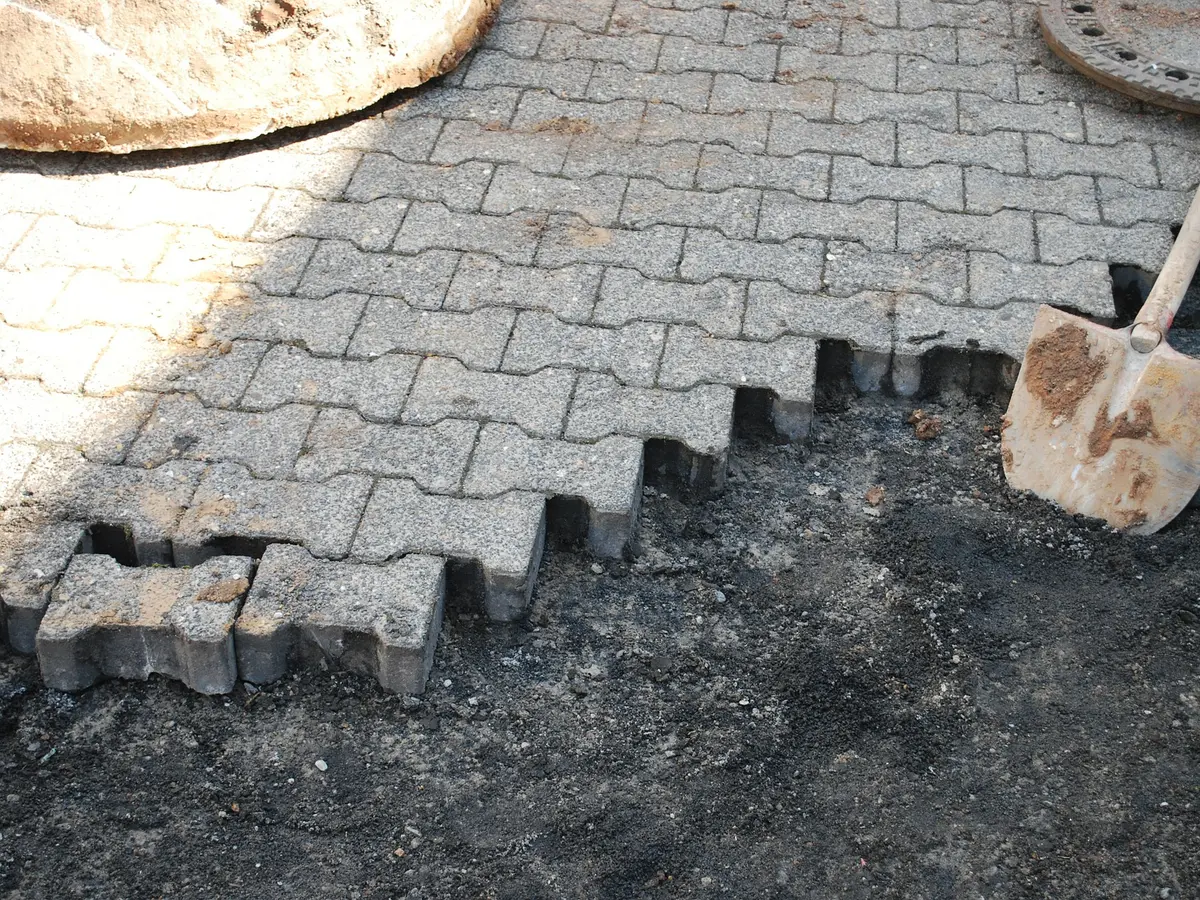 Sunken pavers lifted from a driveway, ready to relay