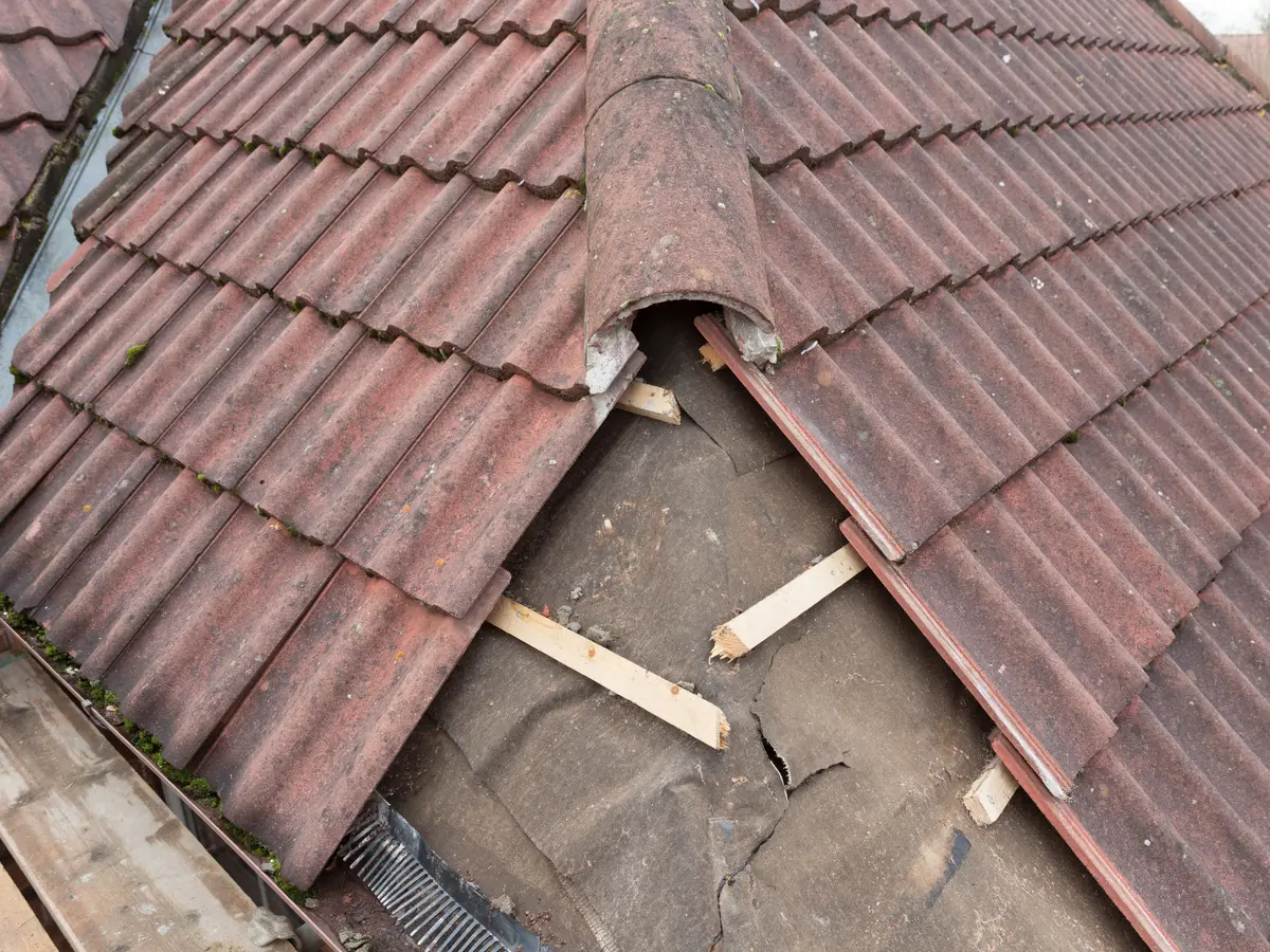 Displaced ridge and roof tiles exposing the underlay and battens