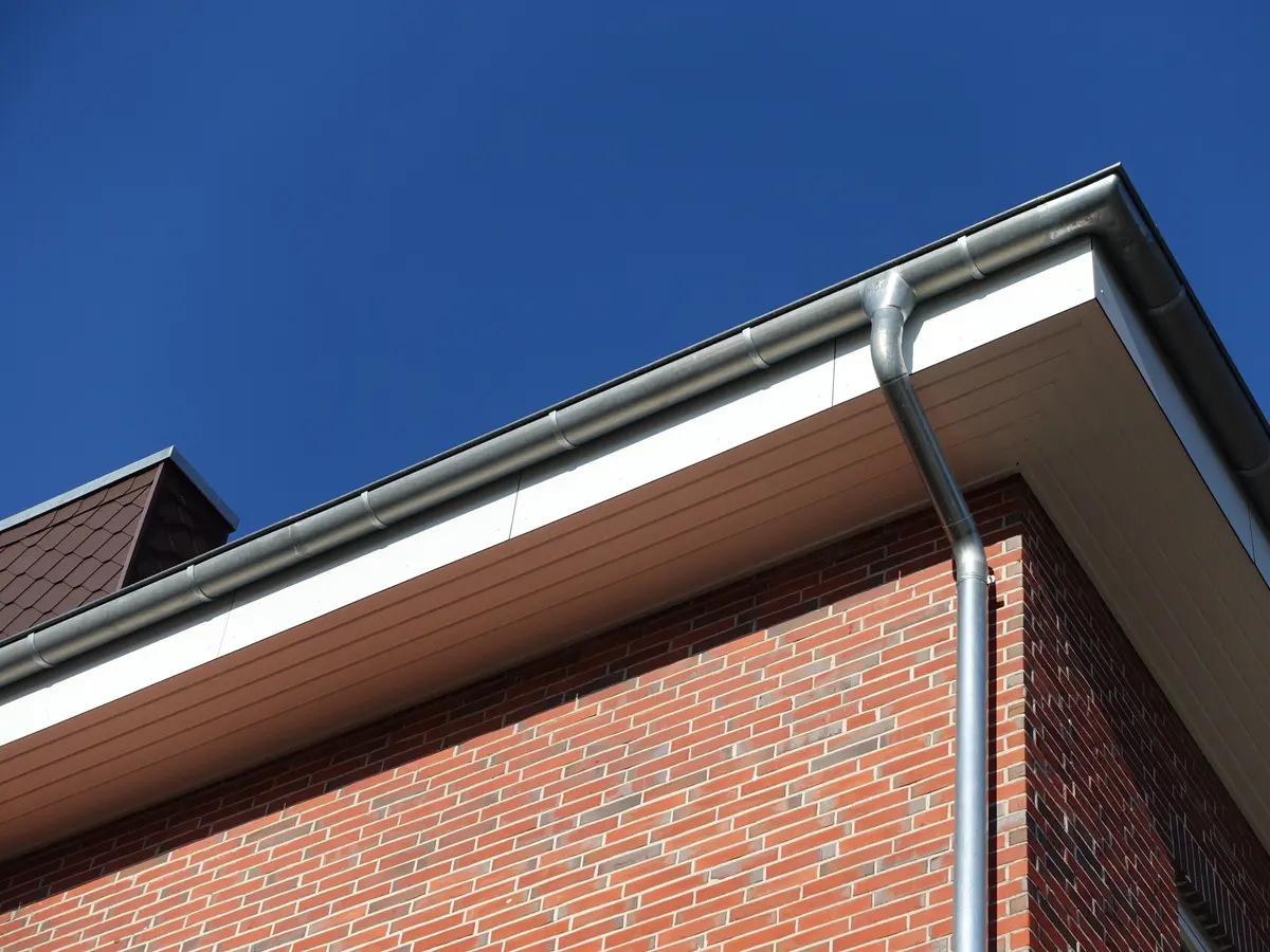 White fascia and soffit with a grey eavestrough on a brick house
