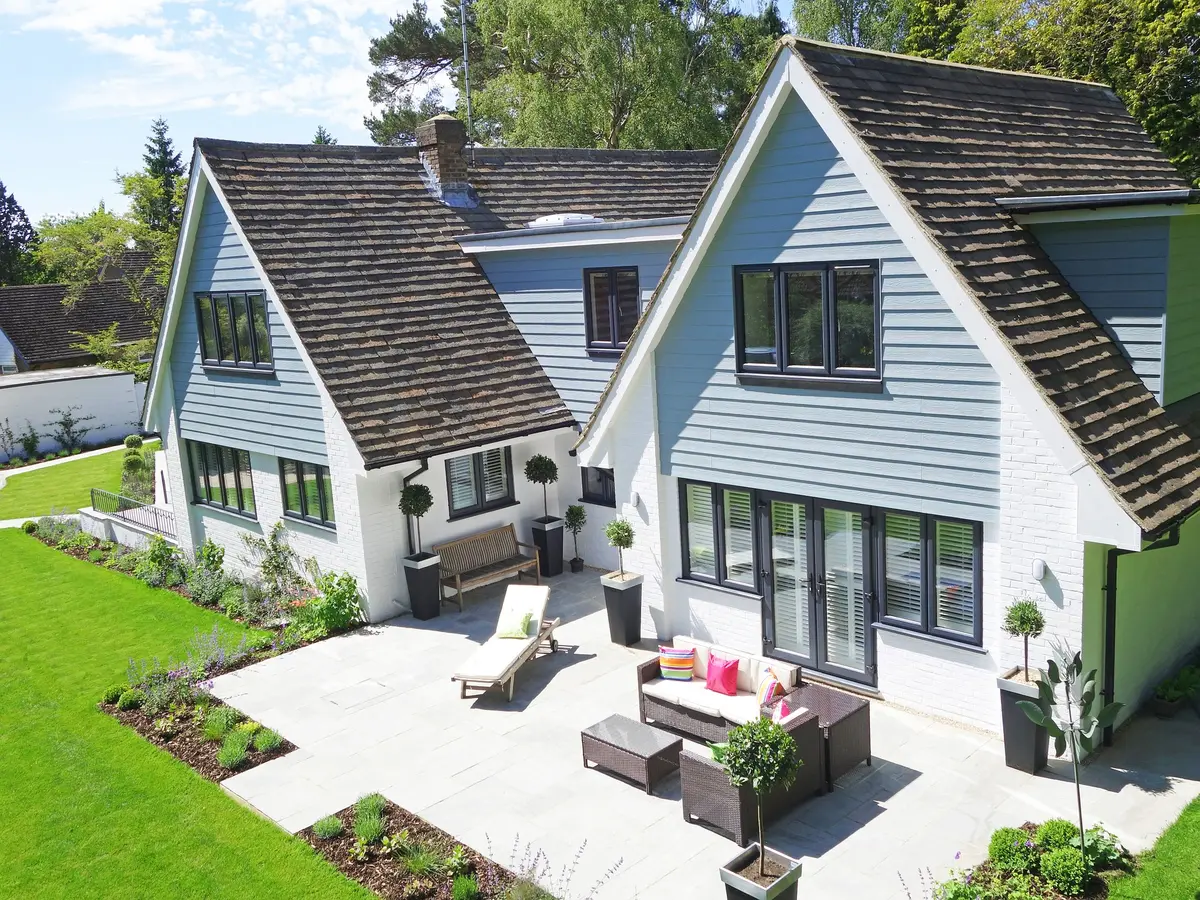 House with blue horizontal siding on its gables above a patio