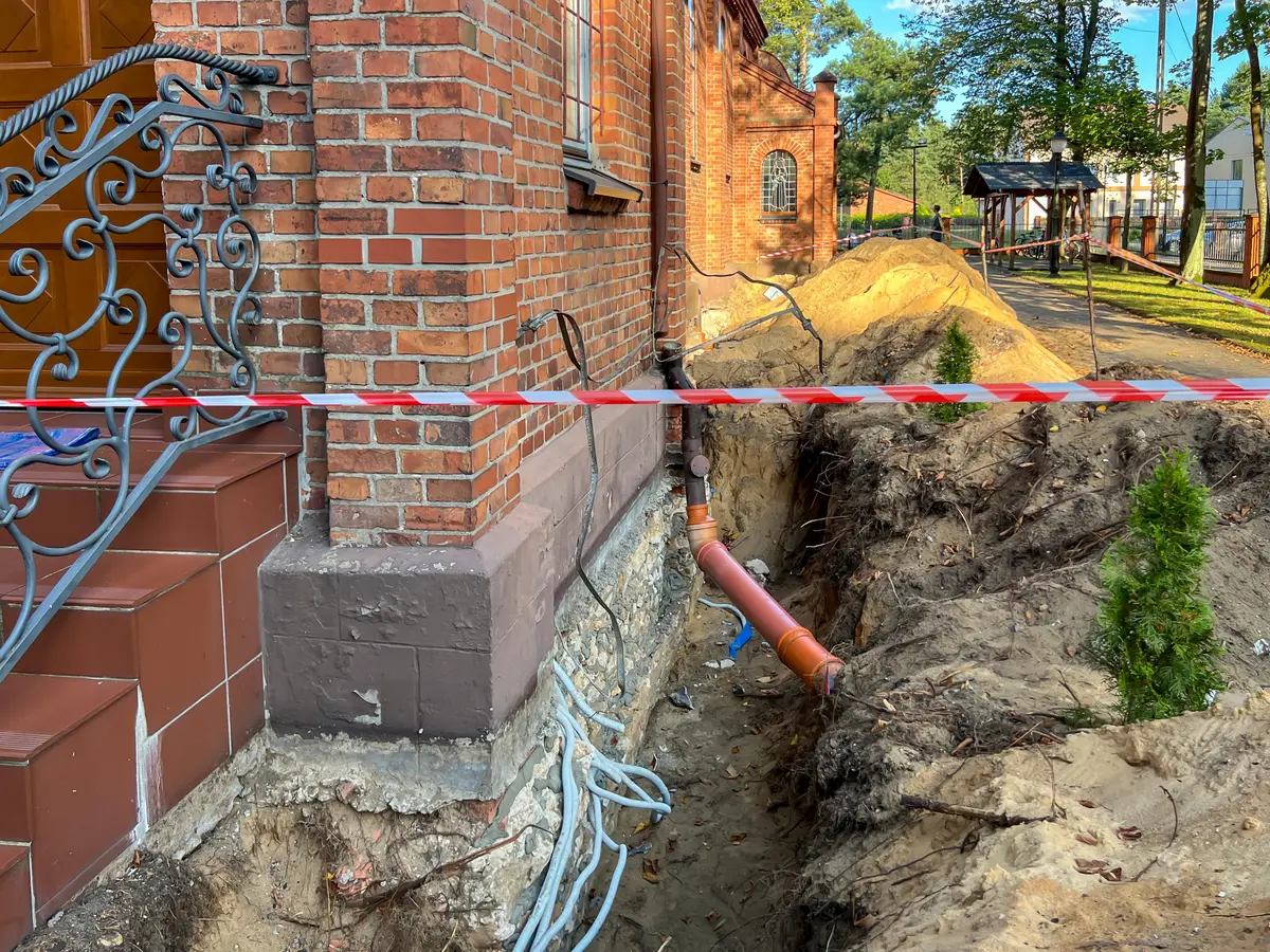 Trench dug along the foundation of a brick house