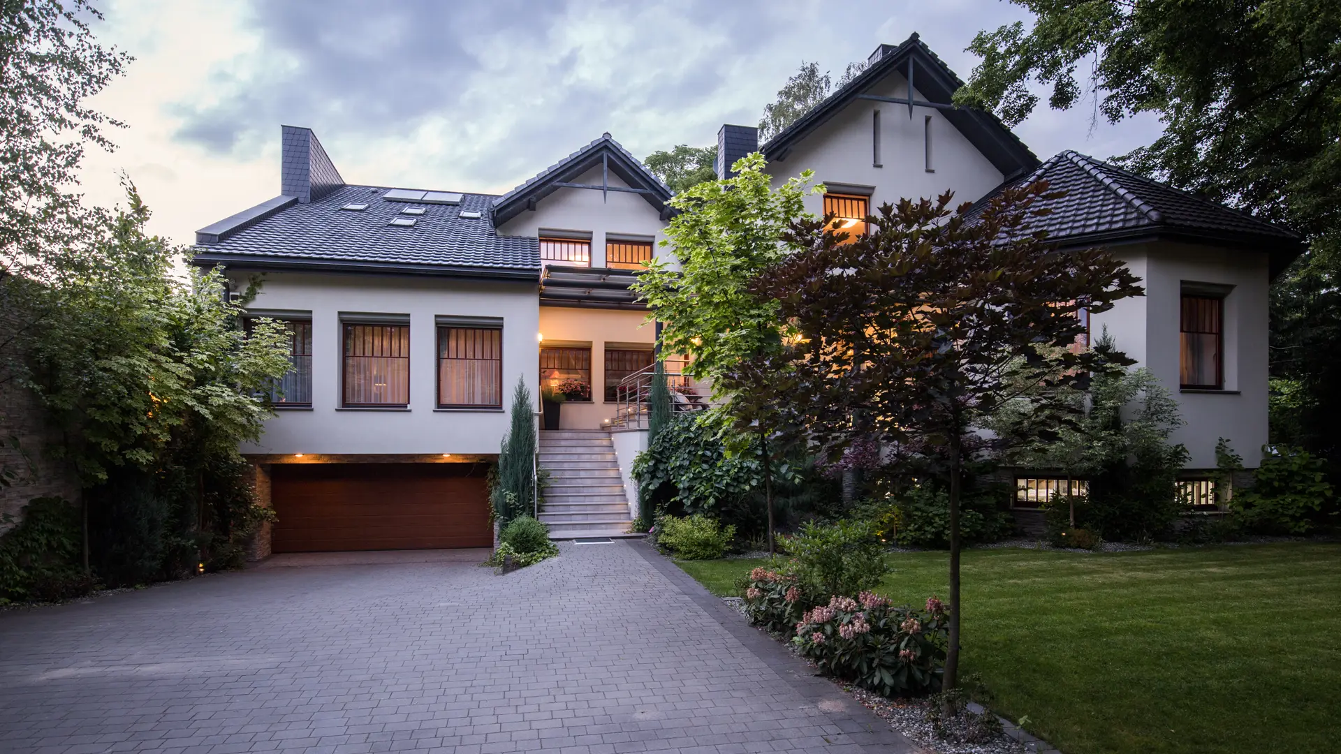Interlocking paver driveway in front of a modern house at dusk