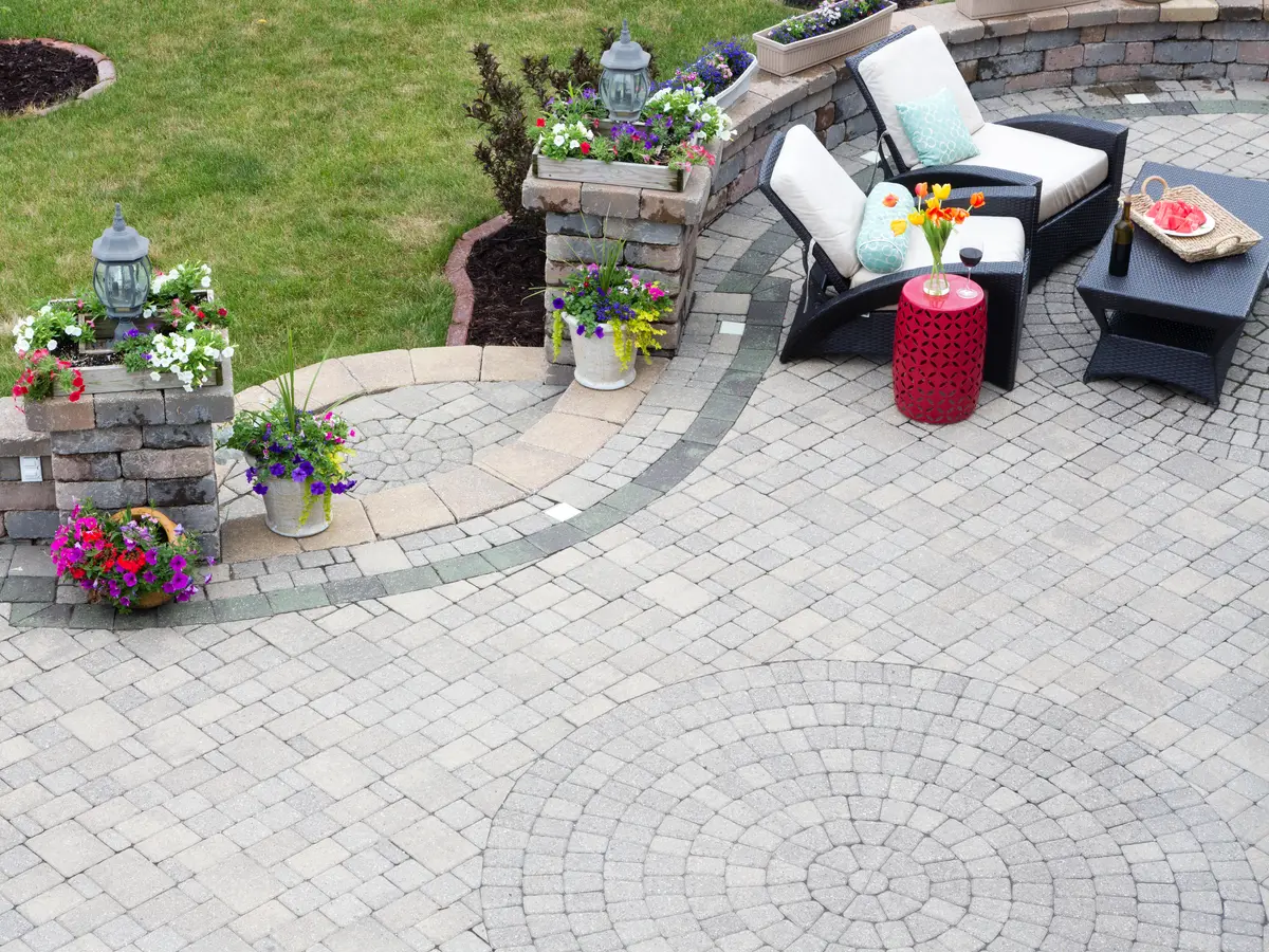 Paver patio with a curved stone seat wall and planters