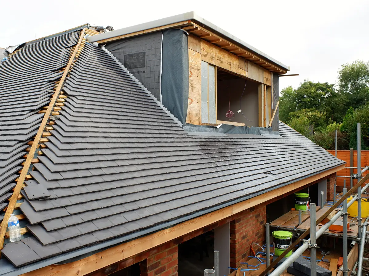 Roof being re-covered on new battens beside a dormer