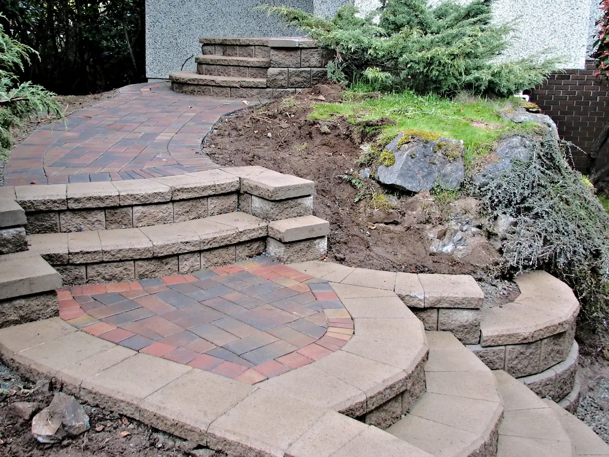 Curved paver steps and landing in a sloped front yard