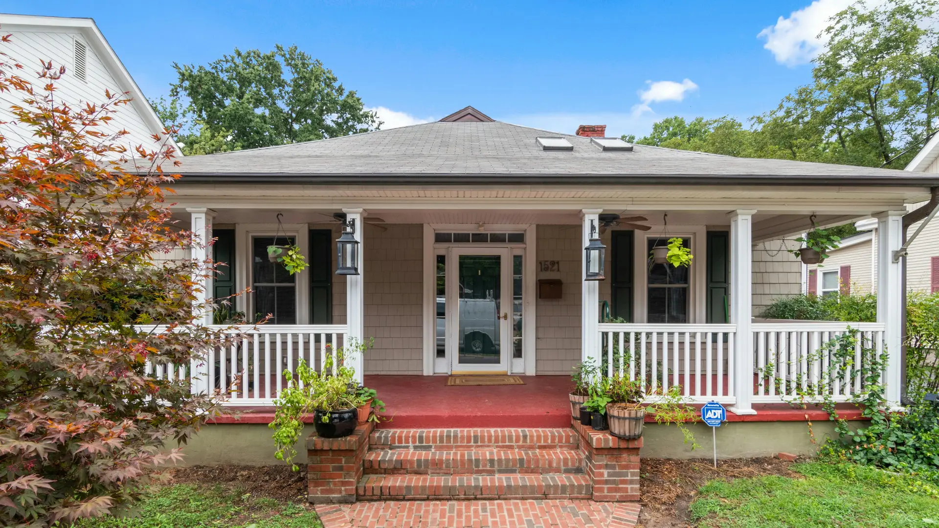 House with a front porch and brick steps leading to a brick walkway